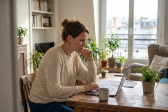 Femme travaillant sur un ordinateur dans un appartement cosy