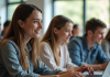 Groupe d'étudiants collaborant sur des ordinateurs dans une salle lumineuse