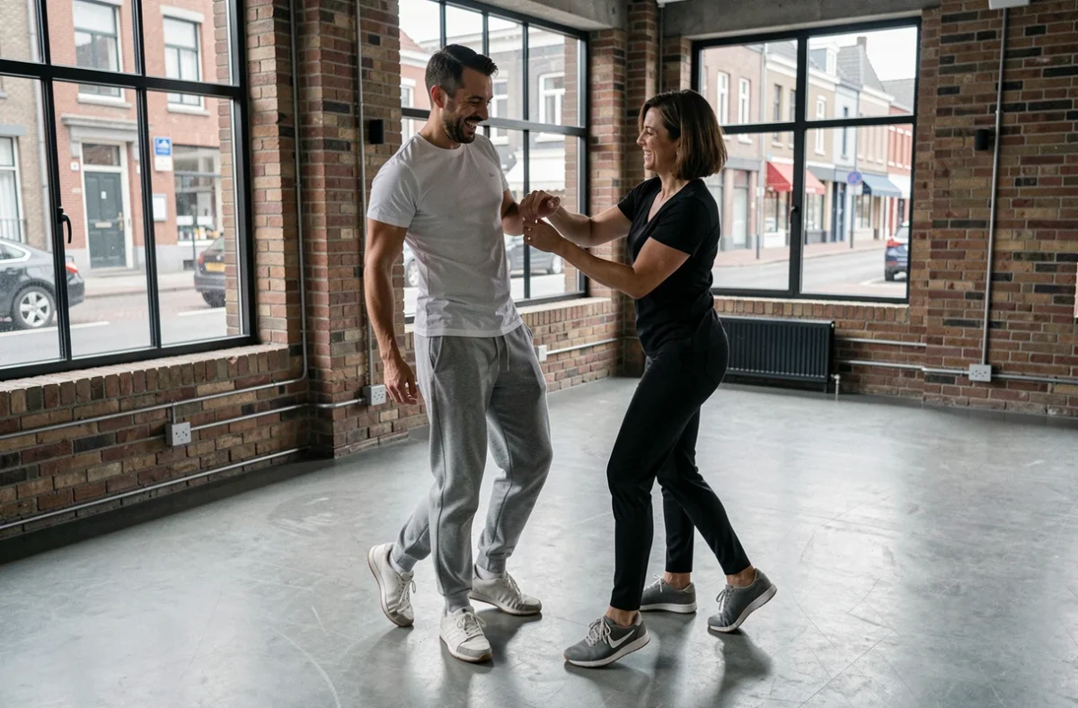Homme adulte débutant un cours de salsa à Lille recevant des corrections de sa professeure de danse